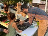 Child learning how to screenprint from a screenprinter