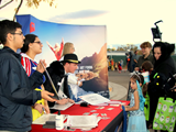 Volunteers at a table handing out candy and info to a trunk or treater