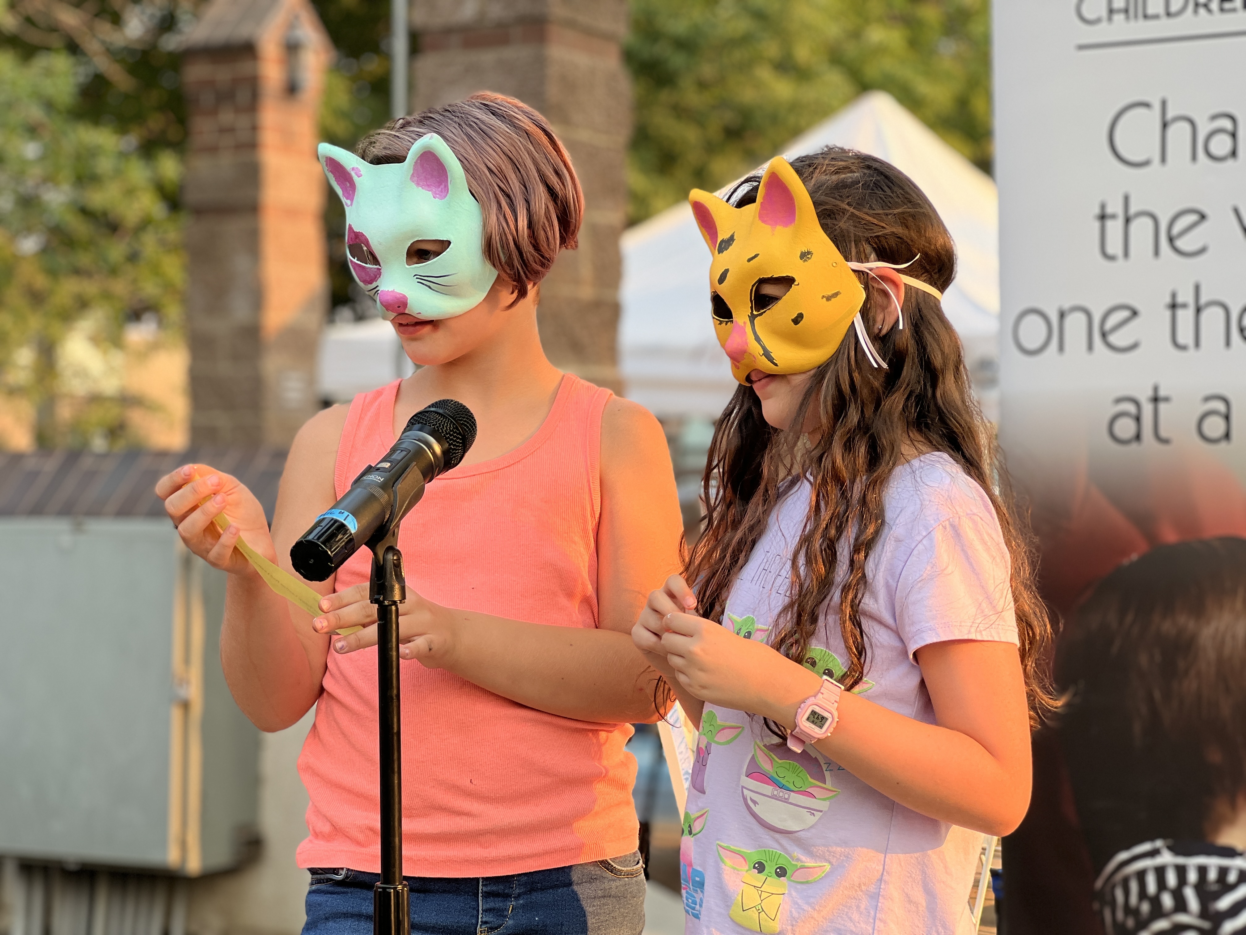 Youth Performers in Masks at a microphone