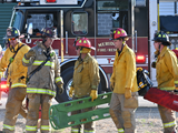 a group of firefighters walking with emergency equipment