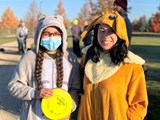Two girls in costume playing disc golf