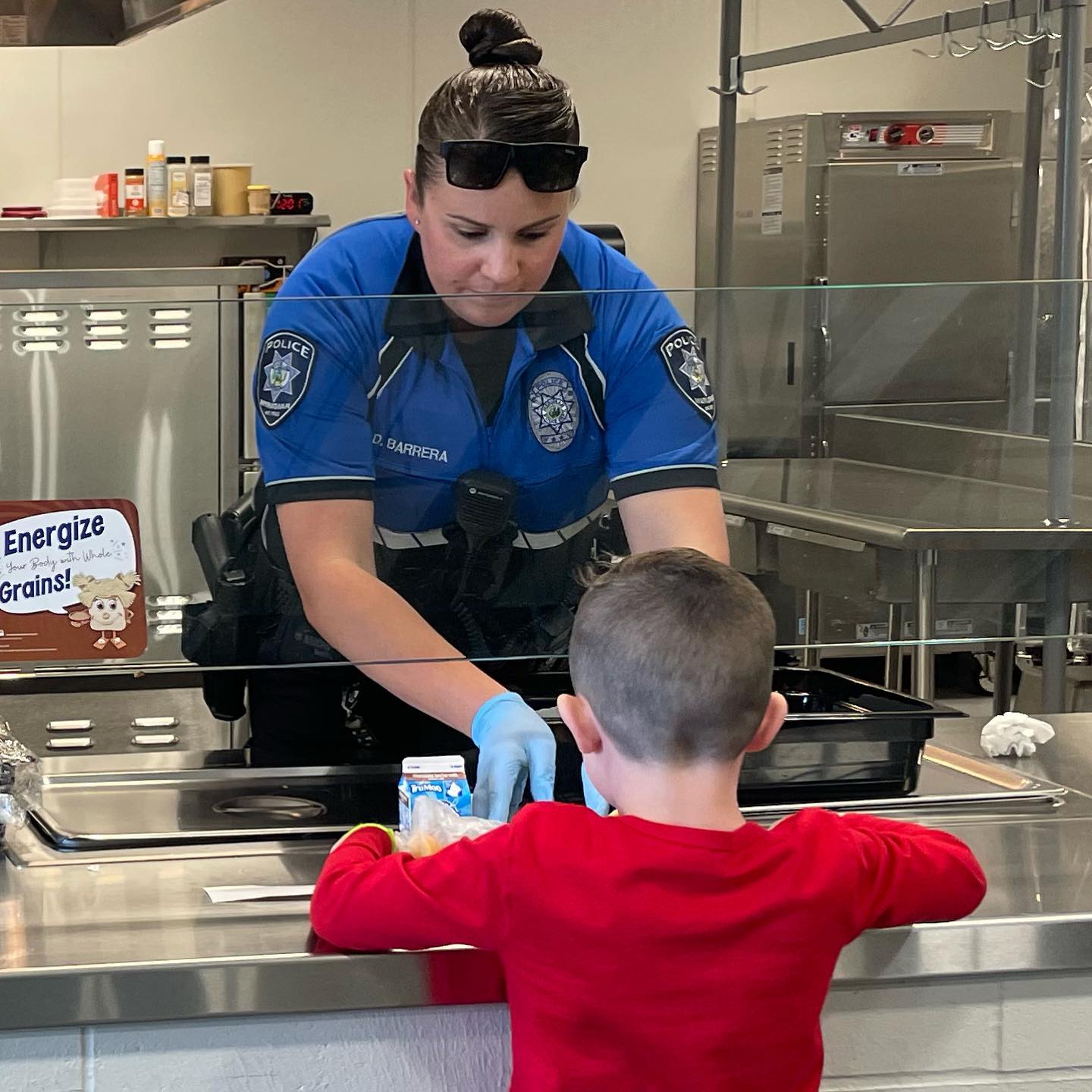 School Resource Officer passing out lunches at a school in Meridian