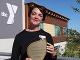 Woman holding City of Meridian Environmental Excellence Award up outside the Meridian YMCA